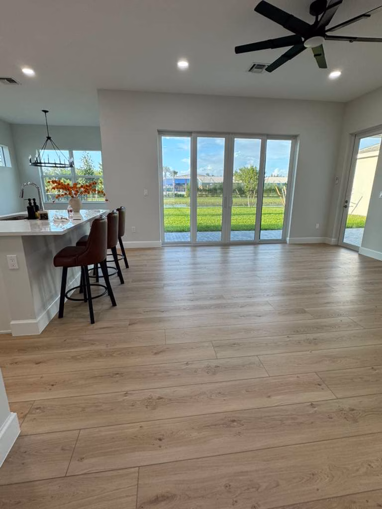 Nuvelle Lux 110 Pearl waterproof vinyl flooring installed in a sunlit South Florida open kitchen and living room.