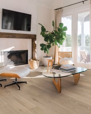 Quick-Step Perrano Loam Oak showing light neutral oak flooring beside a fireplace